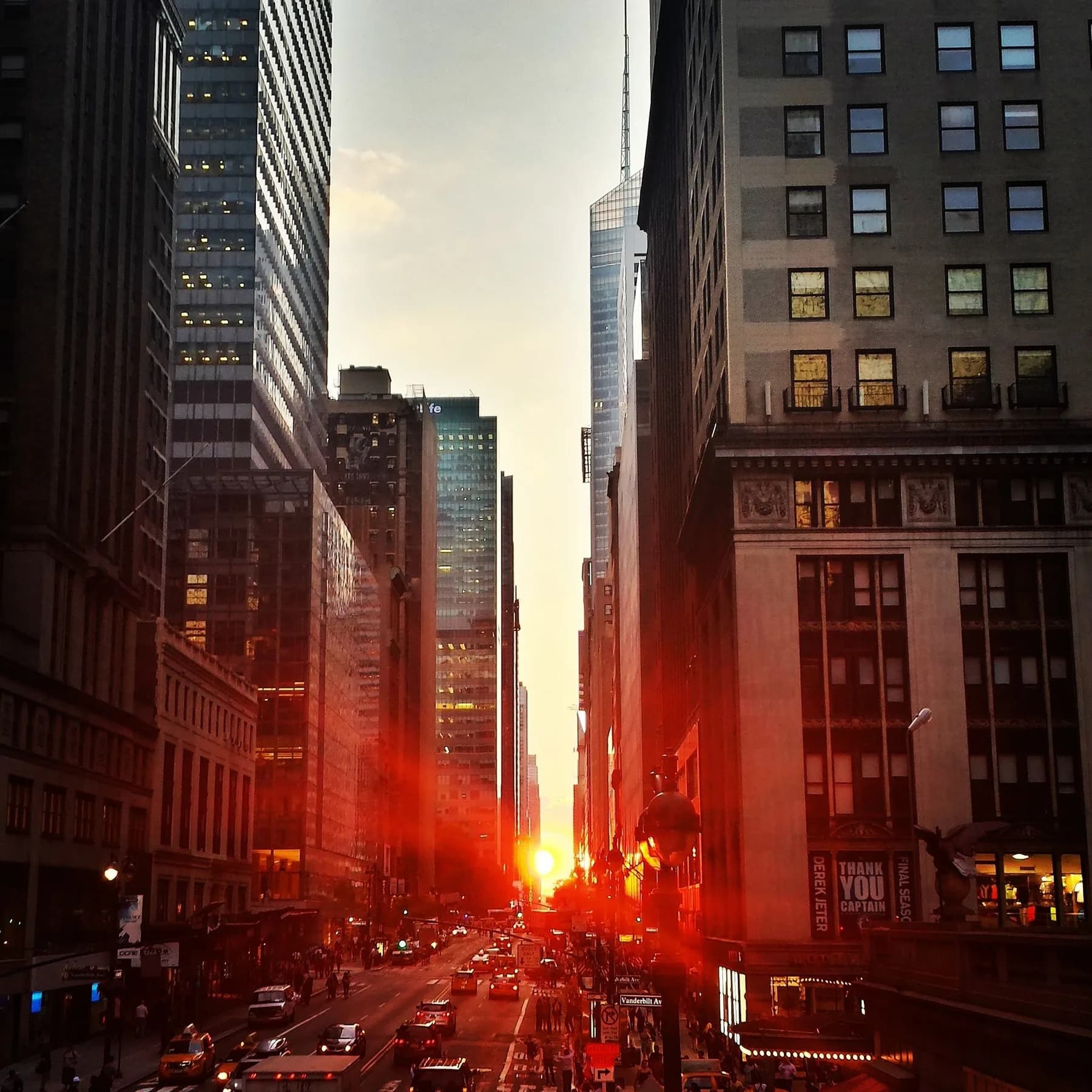 A Manhattan street at sunset between high-rise buildings