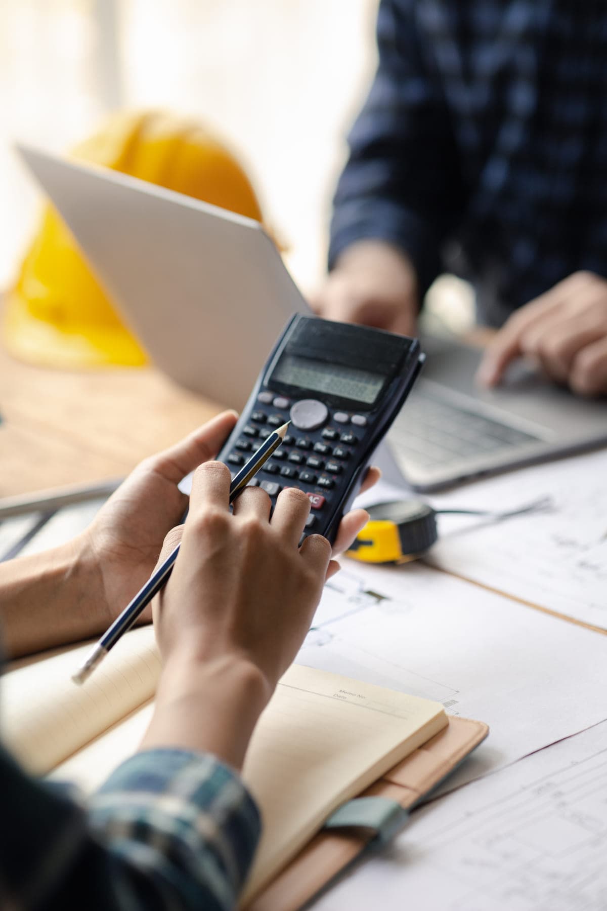 Contractor's team working through job costs with a calculator