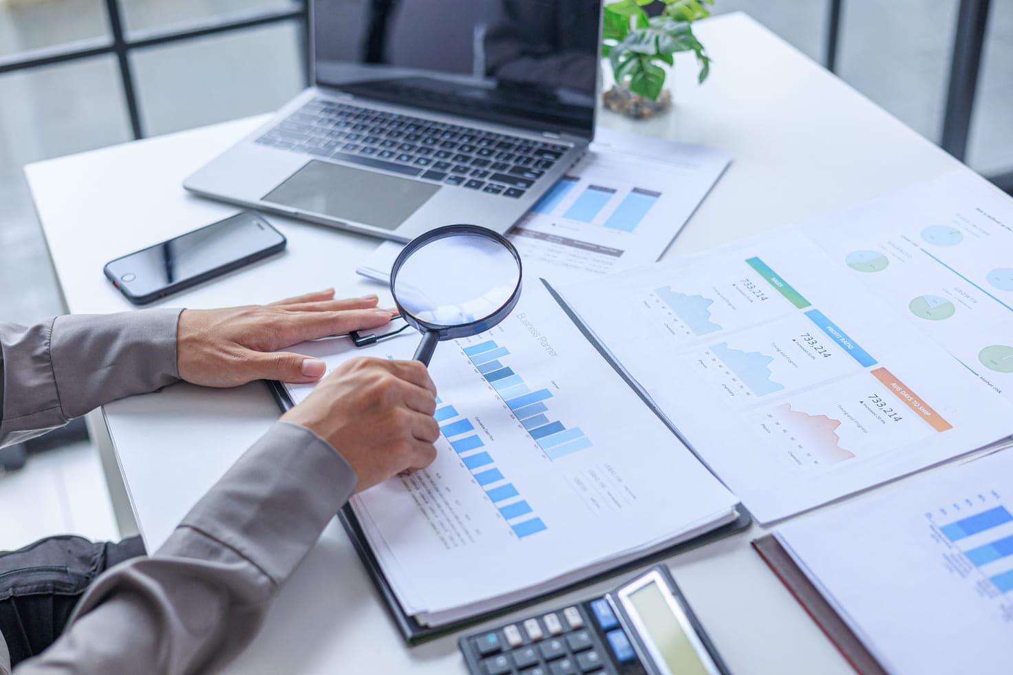 Auditor reviewing financial statements with a magnifying glass