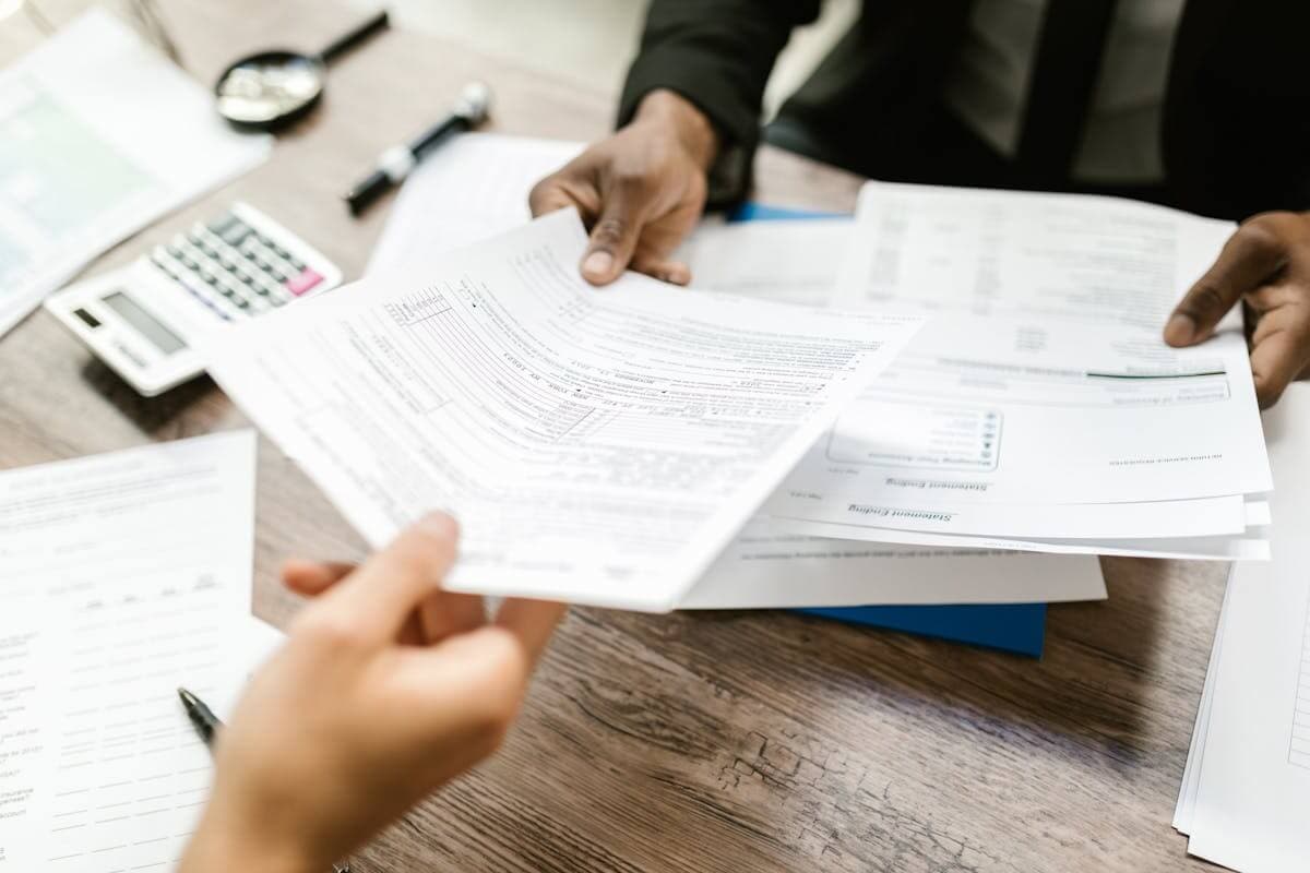 Documents handed across a desk for review